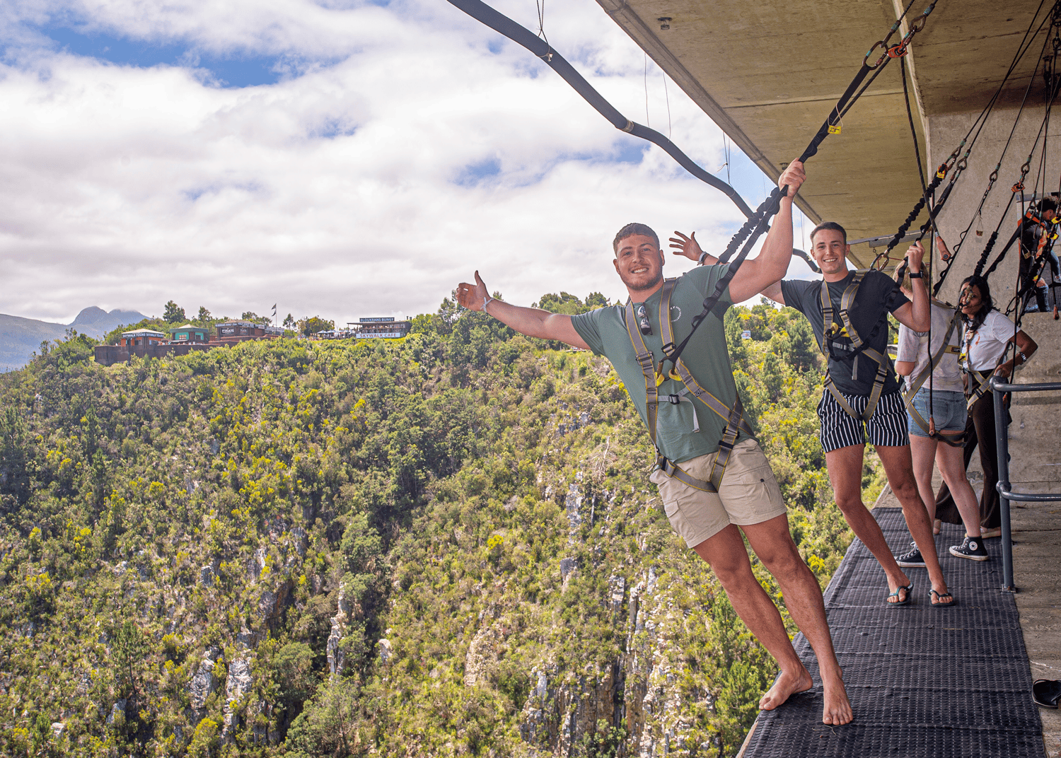 Visitor with arms outstretched on the SkyWalk beneath the Bloukrans Bridge deck